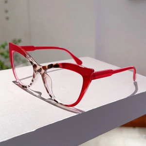 Detail of red cat-eye glasses frame with tortoise pattern accents on the bridge and rim