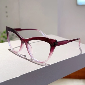 Detail view of cat eye glasses with burgundy gradient frames and clear lenses