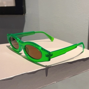 Detail view of neon green oval sunglasses frame with technical specs on the temple