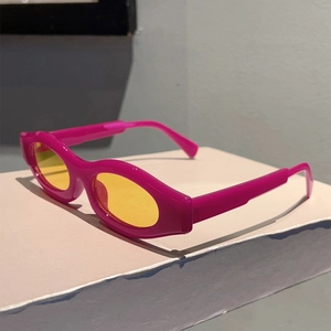 Detail of magenta oval sunglasses with yellow lenses in a retro Y2K fashion style