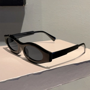 Detail view of black oval retro sunglasses with thick frames on a display stand