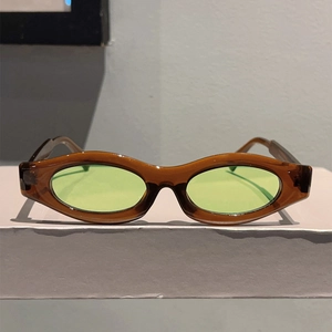 Detail view of oval amber frames and light green lenses on vintage fashion sunglasses