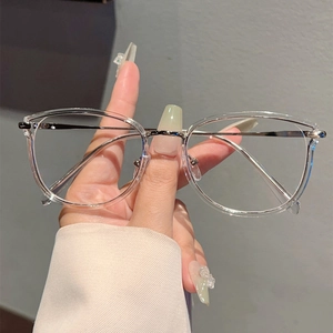 Detail of transparent round eyeglass frame with slim silver metal temples and nose pads