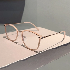 Detail of pink resin frame and slim golden metal temples on a geometric stand