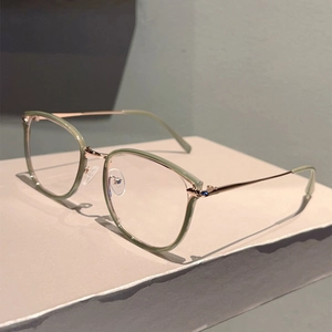 Close-up of retro metal frame glasses with soft green finish and gold temples