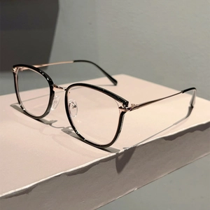 Detail of retro black and rose gold metal frame glasses with soft shadows on stone
