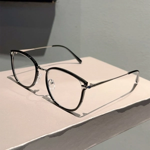 Side view of black frame glasses with slim silver metal temples on a white geometric stand