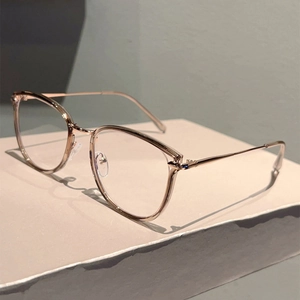Detail view of rose gold metal eyewear frame on white stone base with blue light lenses