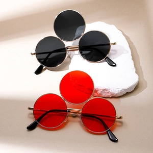 Hip-Hop-Punk Sonnenbrille mit drei runden Gläsern und Goldmetallrahmen auf Stein