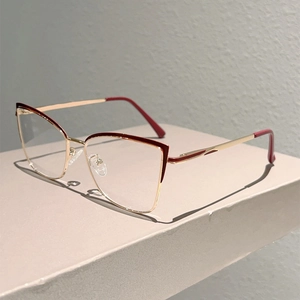 Détail de monture lunettes œil de chat en métal doré et bordeaux avec verre clair