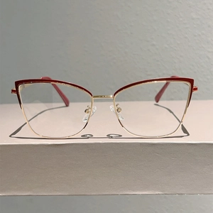 Détail macro de lunettes œil-de-chat avec monture bordeaux et branches dorées