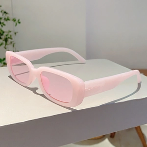 Lunettes de soleil rectangulaires roses avec verres translucides sur support épuré