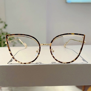 Detailed close-up of tortoise shell cat eye frames with gold metal spring hinge temples