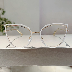 Detail of white cat-eye glasses frame featuring gold metal inlay and comfortable nose pads