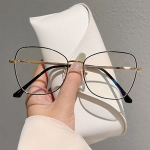 Detail of metal frame glasses with gold temples and a white textured folding case