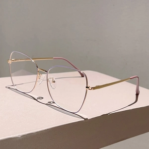 Detail of slim gold metal eyeglass frames with retro butterfly shape and soft nose pads