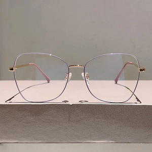 Close-up of stylish metal frame glasses with purple rim and gold spring hinges