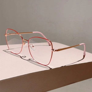 Detail of rose gold cat-eye metal frames and pink temple tips on a geometric stand