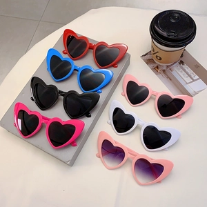 Flat lay of trendy heart-shaped sunglasses in multiple vibrant colors for party styling