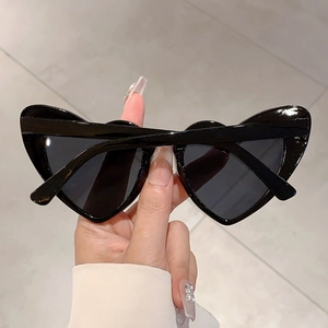 Close-up of heart-shaped sunglasses with glossy black frames and dark tinted lenses