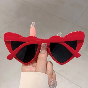 Detail of red heart-shaped sunglasses with pearl trim and dark UV protective lenses