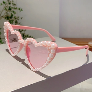 Detailed view of pink heart-shaped sunglasses with intricate pearl bead embellishments