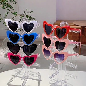 Stylish heart shaped sunglasses set in multiple colors on a clear acrylic display stand