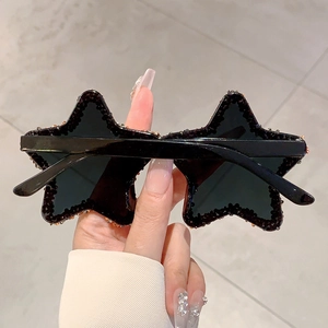 Close-up of star-shaped sunglasses with amber rhinestones for parties and street style