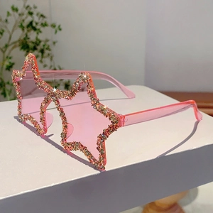 Detail of star-shaped sunglasses featuring pink lenses and sparkling rhinestone edges