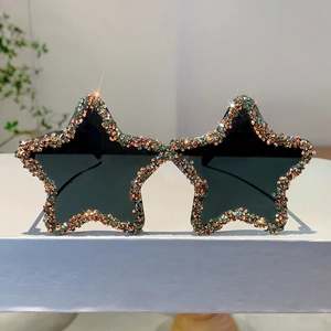 Close-up of star-shaped sunglasses featuring hand-set colorful rhinestones and black lenses
