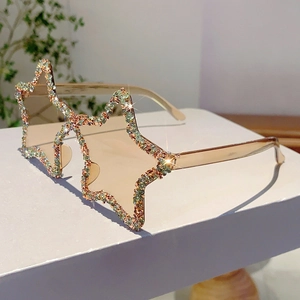 Detailed view of pentagram star sunglasses with colorful rhinestones on champagne frames