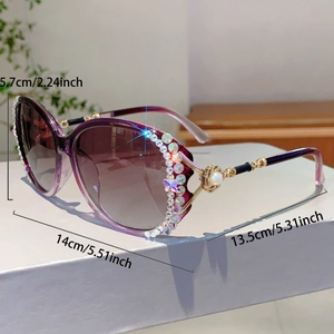 Große Sonnenbrille mit lila Verlaufsgläsern und Strass-Schleife am Gestell im Detail