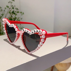 Close-up of red heart sunglasses with pearls and Happy Birthday letter bead detail