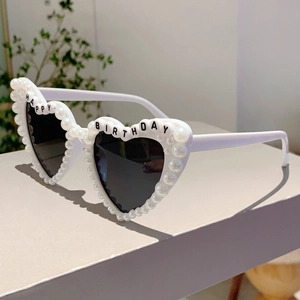 Detail of white heart sunglasses with pearl edges and Happy Birthday text