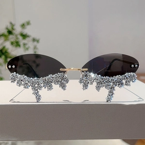 Detail of rimless oval sunglasses with grey lenses and sparkling rhinestone tear drop accents