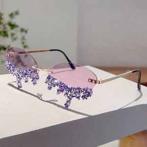 Detail of purple rimless sunglasses with rhinestone teardrop melting design and gold temples