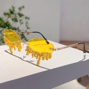Detail of rimless yellow tear-shaped sunglasses with sparkling diamond teardrop accents