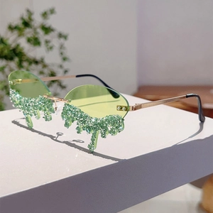 Detail of rimless green sunglasses with dripping crystal teardrops and gold temples