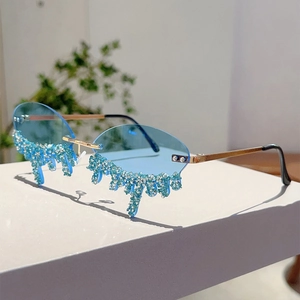 Detail of rimless blue sunglasses with rhinestone tassels on an elegant white pedestal