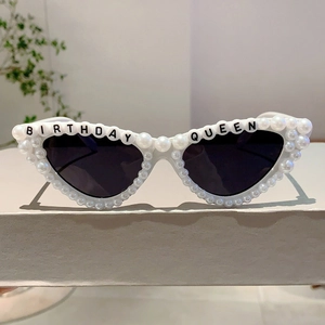 Détail de lunettes de soleil Birthday Queen avec cadre blanc et perles décoratives