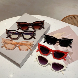 Collection de lunettes de soleil œil-de-chat irrégulières avec détails ailes dorées