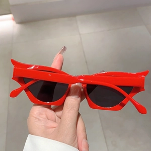 Détail de lunettes de soleil œil de chat rouge vif avec bords pointus et verres noirs