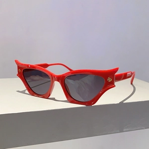 Détail de lunettes de soleil œil-de-chat rouges avec monture en aile de chauve-souris