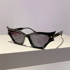 Détail de lunettes de soleil œil de chat noires avec pointes ailées et accents dorés
