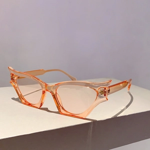 Détail de lunettes œil-de-chat orange avec emblème de cœur doré sur monture translucide
