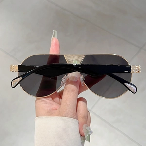 Detail of gold metal bridge with triangle grid texture on classic retro sunglasses
