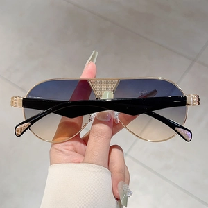 Close-up of luxury gradient lenses and crystal rhinestone bridge on gold metal sunglasses