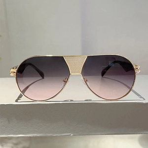 Detail of aviator sunglasses with gold frame and crystal studded bridge detail