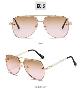 Detail of aviator sunglasses with gold metal frame and gradient pink-brown lenses