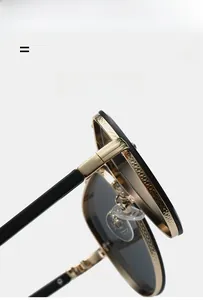 Macro detail of gold and black metal hinge with intricate engraving on pilot sunglasses
